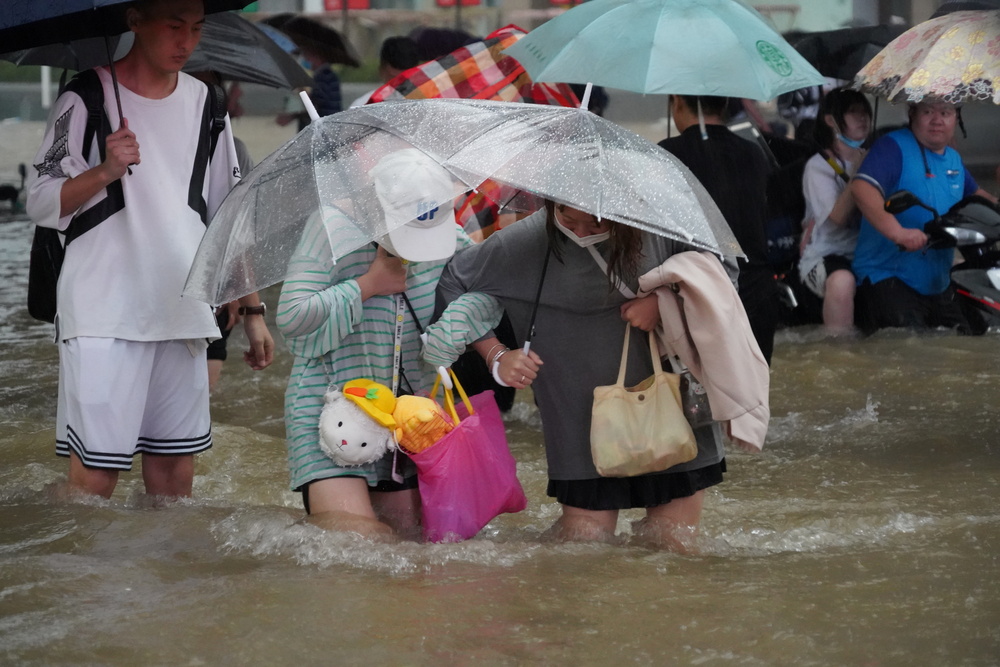 Residents wade through floodwaters in Zhengzhou  / STRINGER