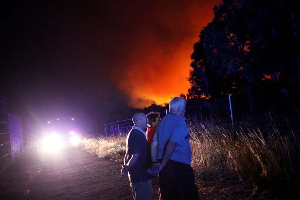 People stand on a road as a wildfire burns in Verin  / FELIPE CARNOTTO
