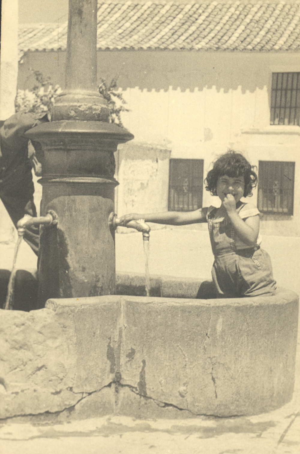 Una niña se refresca dentro de la fuente de Villaluenga. 