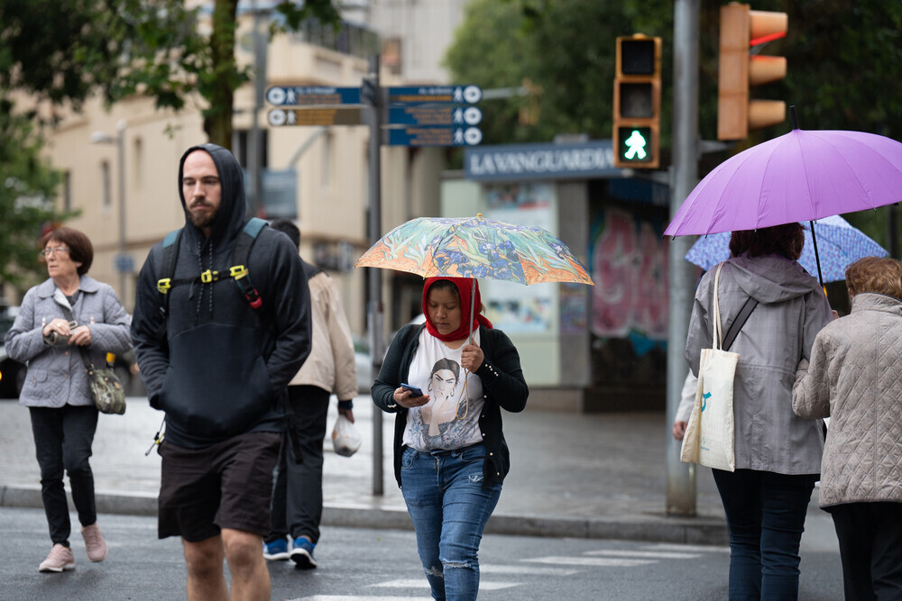 Varias personas pasean por una calle de Barcelona.